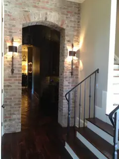 Vestíbulo con puerta, escalera y faroles.