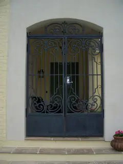 Puertas dobles con reja ornamental.