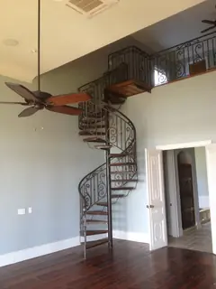 Escalera de caracol junto al ventanal.