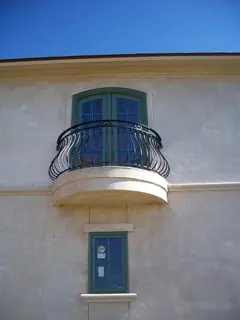 Balcón curvo sobre una ventana.