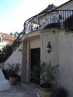 Entrada bajo un balcón curvo.