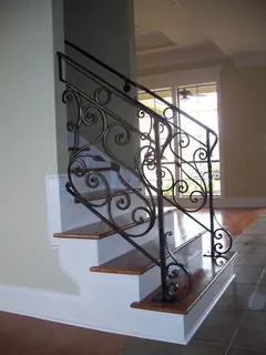 Escalera interior con baranda ornamental.