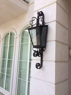 Farol exterior junto a un arco.