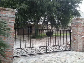 Portón ancho entre pilares de ladrillo.