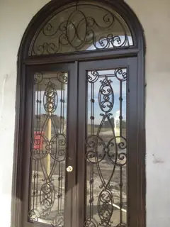 Puerta de vidrio con hierro ornamental.