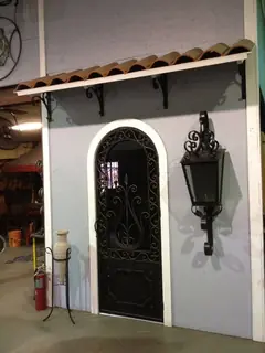 Puerta arqueada junto a farol.