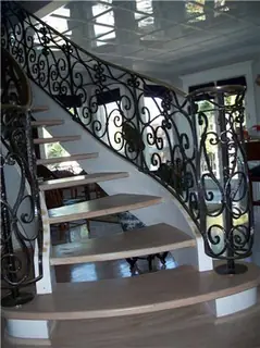 Escalera curva con volutas a contraluz.