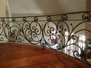 Baranda de volutas junto a una escalera.
