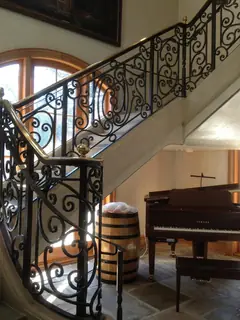 Escalera ornamental junto a un piano.
