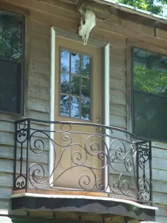 Pequeño balcón en fachada de madera.